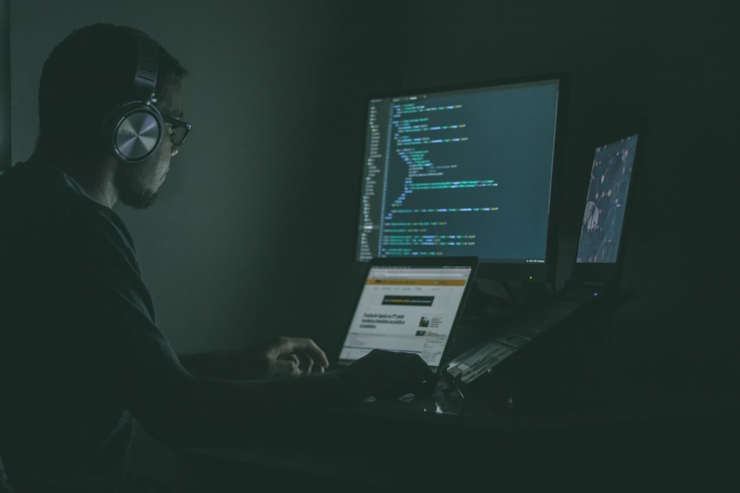 Software developer working with multiple monitors showing code